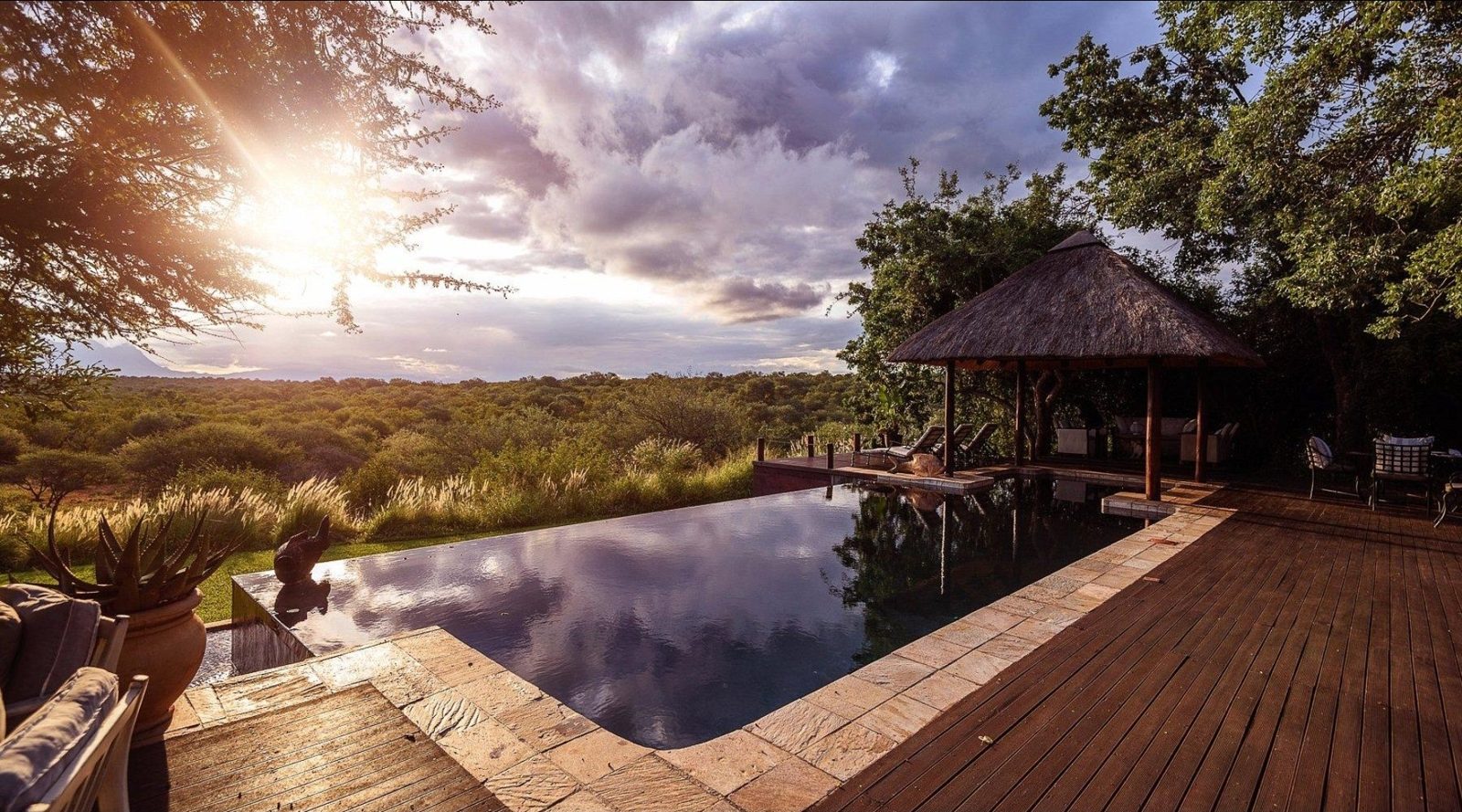 Infinity pool and thatched sala at sunrise